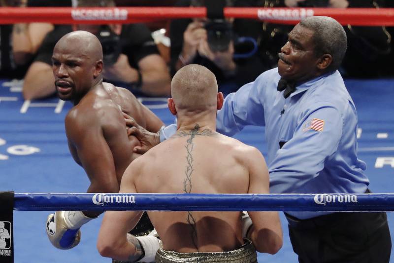 Referee Robert Byrd, right, stops the fight between Floyd Mayweather Jr., left, and Conor McGregor in a super welterweight boxing match Saturday, Aug. 26, 2017, in Las Vegas. (AP Photo/Eric Jamison)