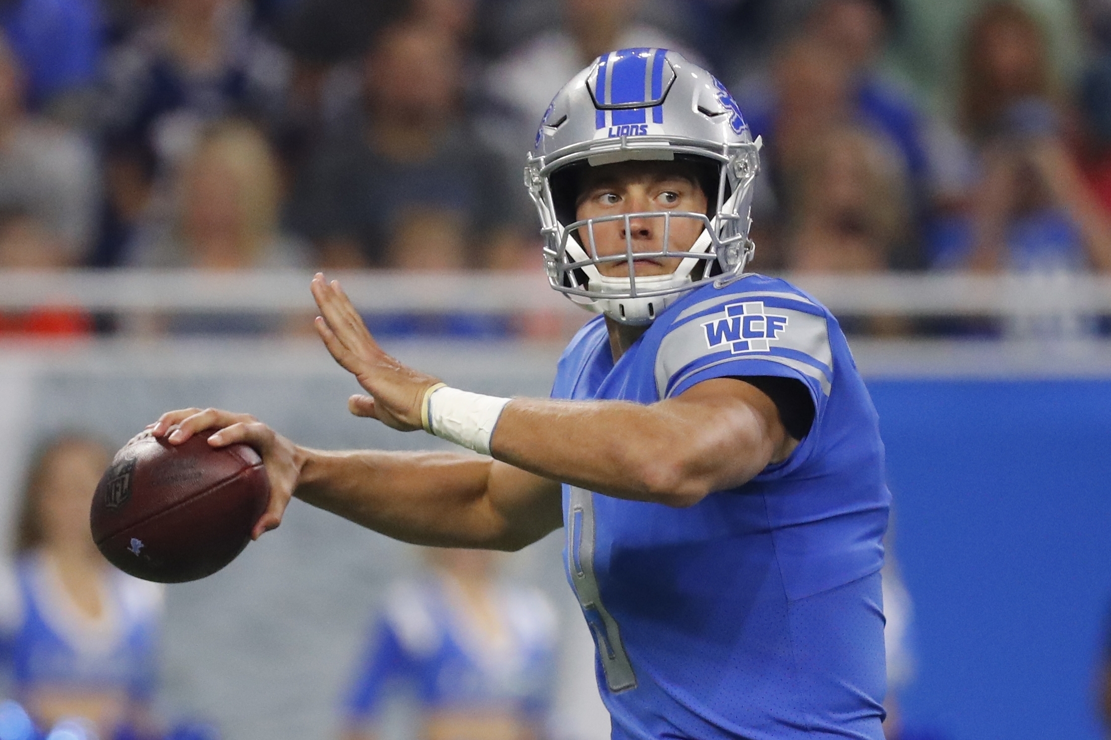 Georgia quarterback Matthew Stafford holds up his Detroit Lions