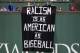 BOSTON, MA - SEPTEMBER 13: Fans display a sign that reads 'Racism is as American as Baseball' over the Green Monster during the fourth inning of a game between the Boston Red Sox and the Oakland Athletics on September 13, 2017 at Fenway Park in Boston, Massachusetts. (Photo by Billie Weiss/Boston Red Sox/Getty Images)