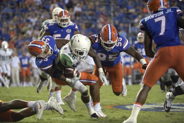 North Texas running back Jeffrey Wilson (26) is tackled by Florida linebacker David Reese (33) and defensive lineman Keivonnis Davis (95) after rushing for yardage during the second half of an NCAA college football game in Gainesville, Fla., Saturday, Sept. 17, 2016. Florida won 32-0. (AP Photo/Phelan M. Ebenhack)