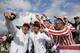 The United States' Phil Mickelson, left and Rickie Fowler take a selfie with fans on the eighth hole during the four-ball golf matches on the third day of the Presidents Cup at Liberty National Golf Club in Jersey City, N.J., Saturday, Sept. 30, 2017. (AP Photo/Julio Cortez)