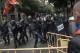 Spanish riot police removes fences thrown by people to them as they try to prevent people from reaching a voting site at a school assigned to be a polling station by the Catalan government in Barcelona, Spain, Sunday, 1 Oct. 2017. Catalan pro-referendum supporters vowed Saturday to ignore a police ultimatum to leave the schools they are occupying to use in a vote seeking independence from Spain. (AP Photo/Felipe Dana)