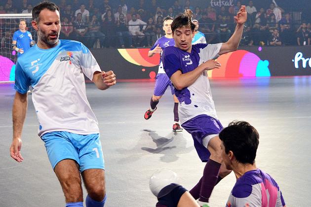 Former Manchester United footballer Ryan Giggs (L) is tackled while taking part in the final of the Indian Premier Futsal Football League match at The Peddem Indoor Stadium in Mapusa on July 24, 2016. / AFP / STR (Photo credit should read STR/AFP/Getty Images)