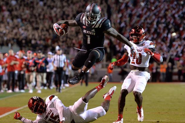 RALEIGH, NC - OCTOBER 05:  Jaylen Samuels #1 of the North Carolina State Wolfpack hurdles Trumaine Washington #15 of the Louisville Cardinals during the game at Carter Finley Stadium on October 5, 2017 in Raleigh, North Carolina.  (Photo by Grant Halverson/Getty Images)