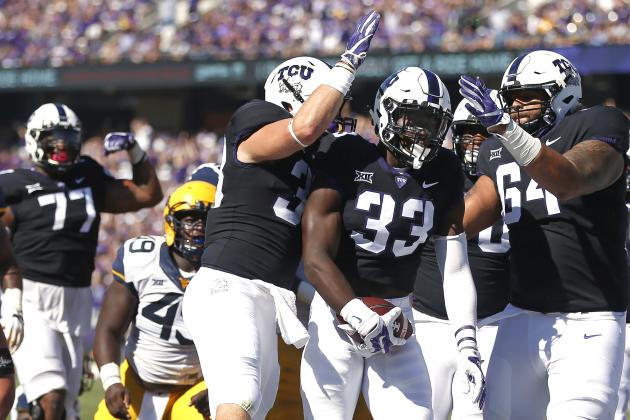 TCU running back Sewo Olonilua (33) celebrates his touchdown against West Virginia with teammates Daythan Davis (38) and Matt Pryor (64) during the first half of an NCAA college football game Saturday, Oct. 7, 2017, in Fort Worth, Texas. (AP Photo/Ron Jenkins)