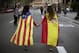 Irene Guszman, 15, wearing a Spanish flag on her shoulders and Mariona Esteve, 14, with an 'estelada' or independence flag, walk along the street to take part on a demonstration in Barcelona, Spain, Tuesday Oct.3, 2017. Thousands of people demonstrated against the confiscation of ballot boxes and charges on unarmed civilians during Sunday's referendum on Catalonia's secession from Spain that was previously declared illegal by Spain's Constitutional Court. (AP Photo/Emilio Morenatti)