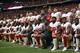 PHOENIX, AZ - OCTOBER 1: The San Francisco 49ers kneel and stand in solidarity on the sideline, during the anthem, prior to the game against the Arizona Cardinals at the University of Phoenix Stadium on October 1, 2017 in Phoenix, Arizona. The Cardinals defeated the 49ers 18-15. (Photo by Michael Zagaris/San Francisco 49ers/Getty Images) *** Local Caption ***