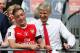 Arsenal's French manager Arsene Wenger (R) and Arsenal's German midfielder Mesut Ozil smile as Arsenal players celebrate their victory over Chelsea in the English FA Cup final football match between Arsenal and Chelsea at Wembley stadium in London on May 27, 2017.
Aaron Ramsey scored a 79th-minute header to earn Arsenal a stunning 2-1 win over Double-chasing Chelsea on Saturday and deliver embattled manager Arsene Wenger a record seventh FA Cup. / AFP PHOTO / Adrian DENNIS / NOT FOR MARKETING OR ADVERTISING USE / RESTRICTED TO EDITORIAL USE (Photo credit should read ADRIAN DENNIS/AFP/Getty Images)
