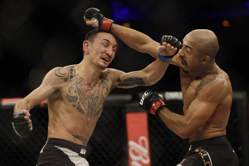 Jose Aldo, of Brazil, left, trades punches with Max Holloway, of the United States, during their UFC featherweight mixed martial arts bout in Rio de Janeiro, Brazil, early Sunday, June 4, 2017. (AP Photo/Leo Correa)