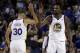 Golden State Warriors' Stephen Curry, left, and Kevin Durant (35) celebrate a score against the Philadelphia 76ers during the second half of an NBA basketball game Saturday, Nov. 11, 2017, in Oakland, Calif. Warriors won, 135-114. (AP Photo/Ben Margot)