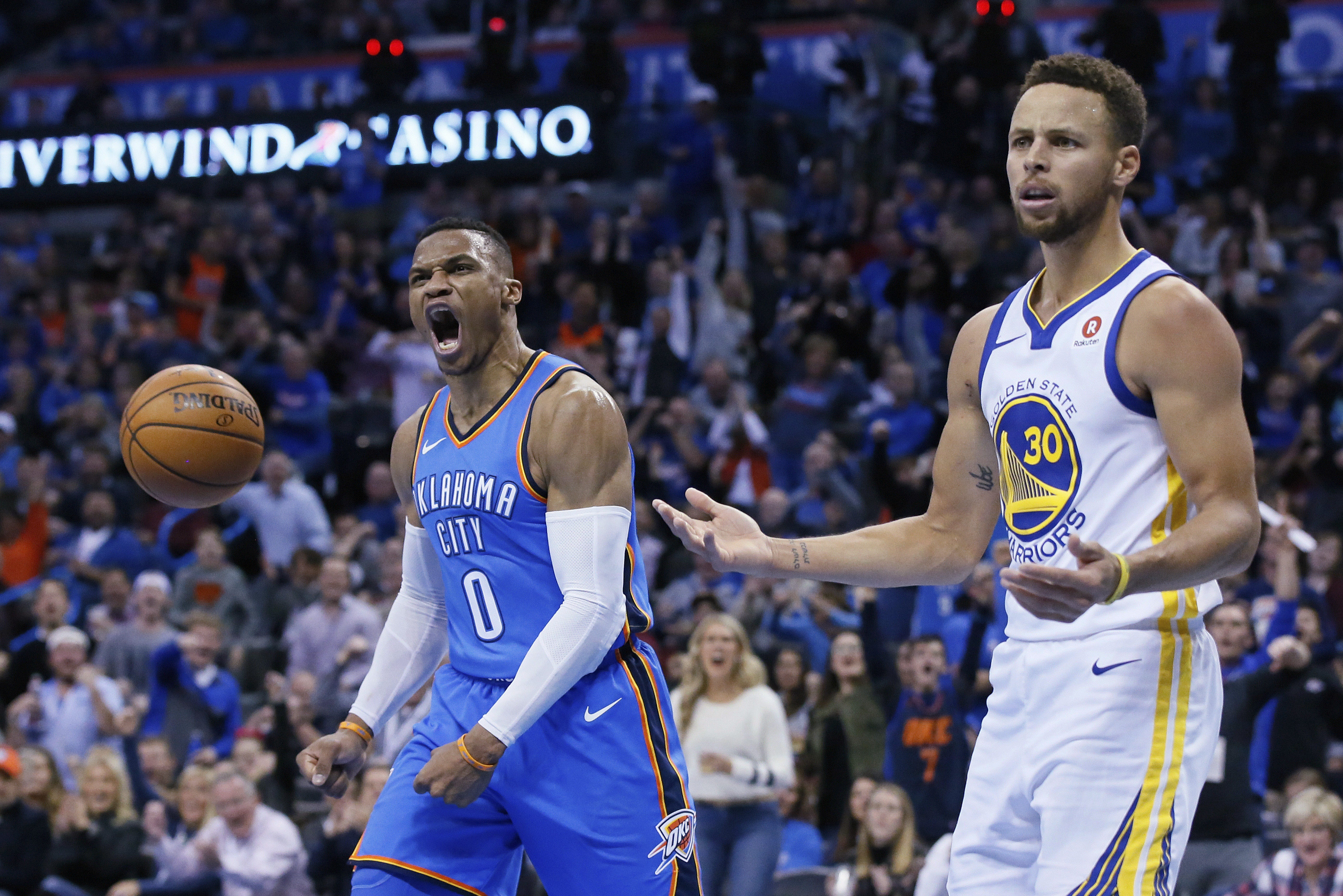 Oklahoma City Thunder guard Russell Westbrook (0) and Golden State Warriors guard Stephen Curry (30) react after Curry was called for a foul on Westbrook during the third quarter of an NBA basketball game in Oklahoma City, Wednesday, Nov. 22, 2017. (AP Photo/Sue Ogrocki)
