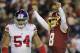 Washington Redskins quarterback Kirk Cousins (8) celebrates wide receiver Josh Doctson's touchdown as he walk past New York Giants defensive end Olivier Vernon (54) during the second half of an NFL football game in Landover, Md., Thursday, Nov. 23, 2017. (AP Photo/Mark Tenally)