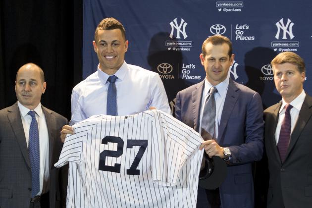 Yankees General Manager Brian Cashman, left, stands next to new Yankee Giancarlo Stanton, center, and his new jersey with Yankee Manager Aaron Boone, right middle, and Yankee Owner Hal Steinbrenner, right, during the Major League Baseball winter meetings in Orlando, Fla., Monday, Dec. 11, 2017. (AP Photo/Willie J. Allen Jr.)
