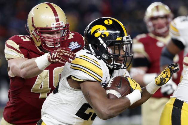 Boston College linebacker Kevin Bletzer (49) prepares to tackle Iowa running back Akrum Wadley (25) who runs with the ball during the first quarter of the Pinstripe Bowl NCAA college football game, Wednesday, Dec. 27, 2017, in New York. (AP Photo/Kathy Willens)