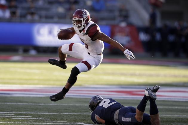 New Mexico State running back Larry Rose III (3) leaps over Utah State safety Dallin Leavitt in the first half of the Arizona Bowl NCAA college football game Friday, Dec. 29, 2017, in Tucson, Ariz. (AP Photo/Rick Scuteri)
