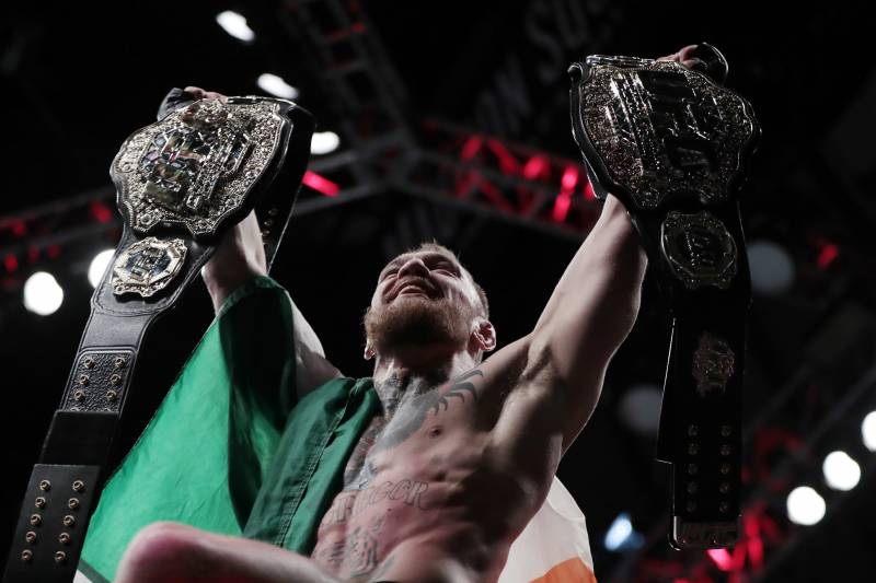 Conor McGregor holds up his title belts after he defeated Eddie Alvarez during a lightweight title mixed martial arts bout at UFC 205, early Sunday, Nov. 13, 2016, at Madison Square Garden in New York. (AP Photo/Julio Cortez)