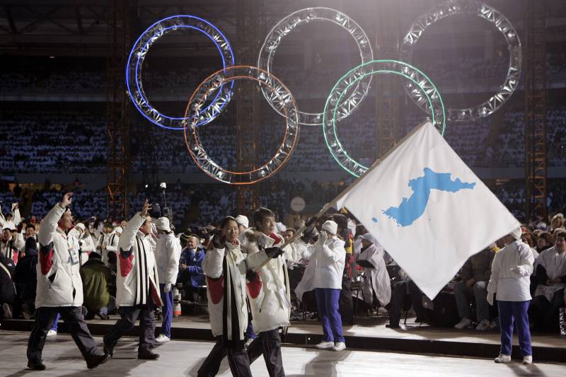 FILE - In this Feb. 10, 2006, file photo, Korea flag-bearer's Bora Lee and Jong-In Lee, carrying a unification flag lead their teams into the stadium during the 2006 Winter Olympics opening ceremony in Turin, Italy. North Korea plans to send a spotlight-stealing delegation to next month’s Winter Olympics in the South Korean county of Pyeongchang. (AP Photo/Amy Sancetta, File)