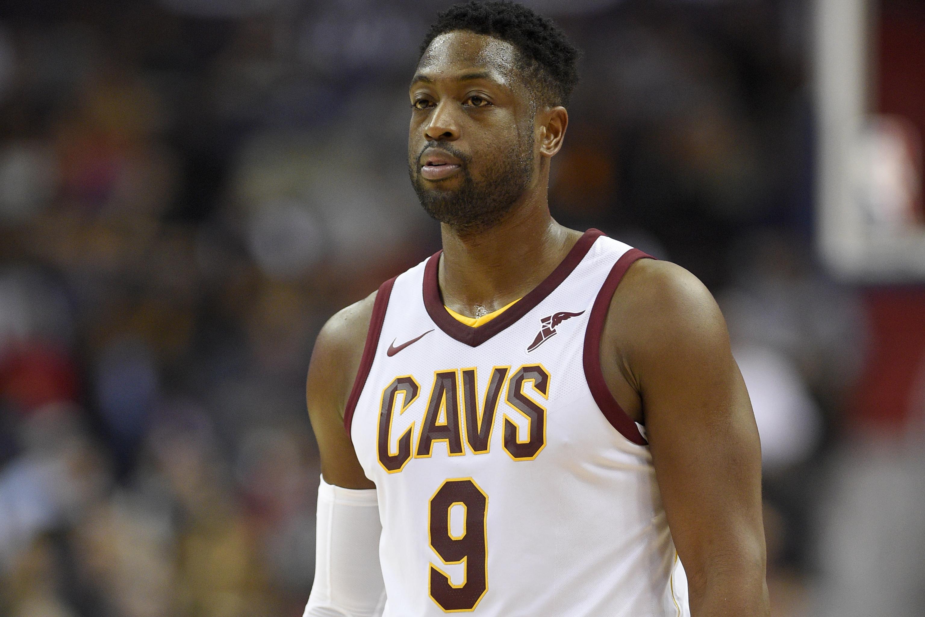 The Miami Heat's Dwyane Wade, left, holds a jersey with the number 11 that  honors his former agent Henry Thomas, who died in 2018, while teammate  Udonis Haslem, right, holds Wade's jersey