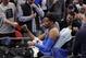 Oklahoma City Thunder guard Andre Roberson fist-bumps a fan as he is carted off after slipping during the second half of the team's NBA basketball game against the Detroit Pistons, Saturday, Jan. 27, 2018, in Detroit. (AP Photo/Carlos Osorio)