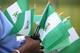 An unidentified woman sells Nigerian national flags, during an event to mark Nigeria independence day, in Lagos, Nigeria. Tuesday, Oct. 1, 2013 . Nigeria marked 53 years of independence Tuesday with little to celebrate, scores of families are in mourning over killings by suspected Islamic extremists, security forces on high alert against feared bomb attacks and the government rift by an internal power struggle. (AP Photo/Sunday Alamba)