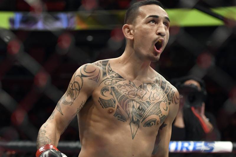 Max Holloway jogs around the ring as he waits for Jose Aldo of Brazil to arrive for their UFC 218 featherweight mixed martial arts bout, early Sunday, Dec. 3, 2017, in Detroit. Holloway defeated Aldo by third-round TKO. (AP Photo/Jose Juarez)