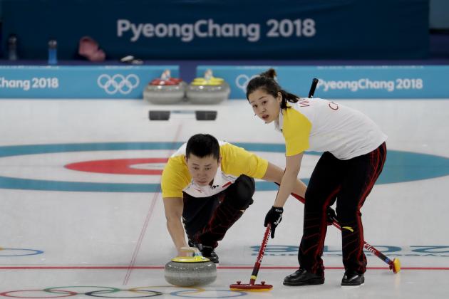 China's Wang Rui, right, sweeps the ice as teammate Ba Dexin watches during a mixed double curling match against South Korea's Jang Hyeji and Lee Kijeong at the 2018 Winter Olympics in Gangneung, South Korea, Thursday, Feb. 8, 2018. (AP Photo/Natacha Pisarenko)