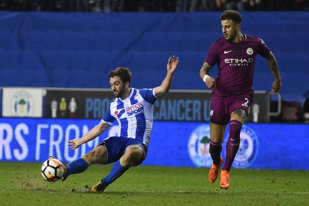 Wigan Athletic's English-born Northern Irish striker Will Grigg (L) scores his team's first goal during the English FA Cup fifth round football match between Wigan Athletic and Manchester City at the DW Stadium in Wigan, northwest England, on February 19, 2018. / AFP PHOTO / Oli SCARFF / RESTRICTED TO EDITORIAL USE. No use with unauthorized audio, video, data, fixture lists, club/league logos or 'live' services. Online in-match use limited to 75 images, no video emulation. No use in betting, games or single club/league/player publications.  /         (Photo credit should read OLI SCARFF/AFP/Getty Images)