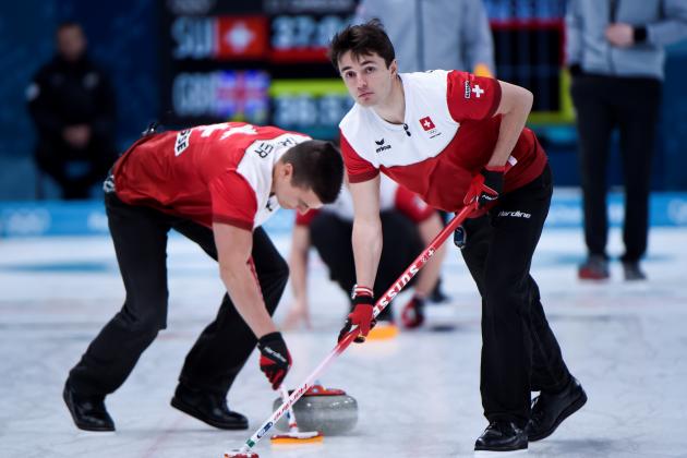 Switzerland's Benoit Schwarz (R) brushes in front of the stone with his teammate during the curling men's semi-final game during the Pyeongchang 2018 Winter Olympic Games at the Gangneung Curling Centre in Gangneung on February 22, 2018. / AFP PHOTO / WANG Zhao        (Photo credit should read WANG ZHAO/AFP/Getty Images)