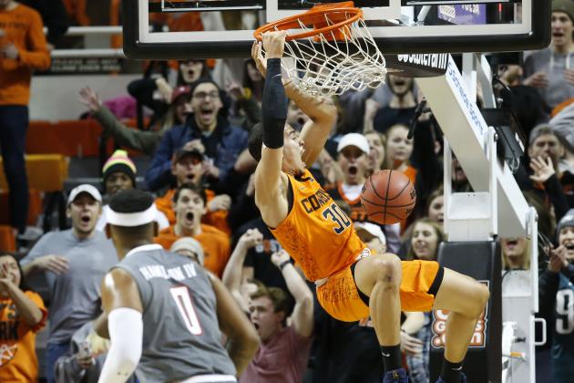 Oklahoma State guard Jeffrey Carroll dunks in front of Texas Tech forward Tommy Hamilton IV (0) during the second half of an NCAA college basketball game in Stillwater, Okla., Wednesday, Feb. 21, 2018. (AP Photo/Sue Ogrocki)