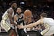 San Antonio Spurs' Patty Mills, center, from Australia, drives between Cleveland Cavaliers' Jeff Green, left, and Kyle Korver in the first half of an NBA basketball game, Sunday, Feb. 25, 2018, in Cleveland. (AP Photo/Tony Dejak)