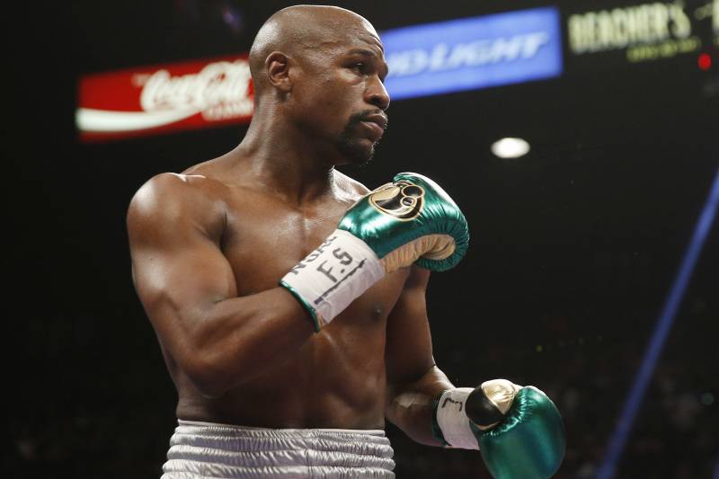 FILE - In this Sept. 12, 2015, file photo, Floyd Mayweather Jr. fights Andre Berto (not shown) during their welterweight title in Las Vegas. It%26#x2019;s still early, but give Round 1 of the trash talk battle between Conor McGregor and Mayweather Jr. to the Irish MMA star. (AP Photo/Steve Marcus, File)