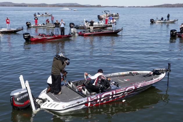Randall Tharp, Port Saint Joe, Fla., holds up a bass for spectators following him on the second day of the Bassmaster Classic, Saturday, Feb. 22, 2014, in Guntersville, Ala. Tharp was bumped from first to second by 1 ounce by Edwin Evers, Talala, Okla. The field will be cut to the top 25 anglers for the final day of competition. (AP Photo/Hal Yeager)