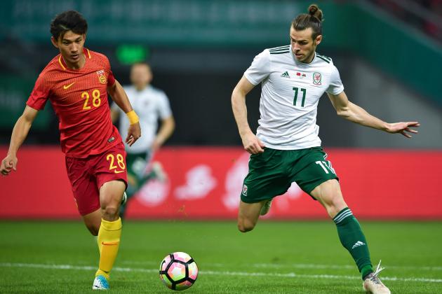 Gareth Bale (R) of Wales competes for the ball with Wang Shenchao of China during their China Cup International Football Championship Semi-final match in Nanning in China's southern Guangxi region on March 22, 2018. / AFP PHOTO / - / China OUT (Photo credit should read -/AFP/Getty Images)