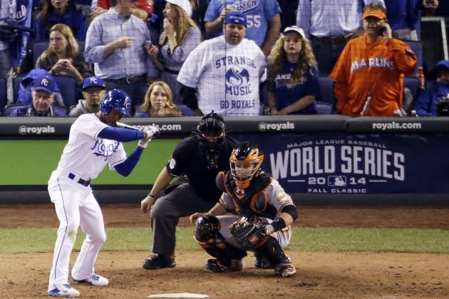 In this Wednesday, Oct. 22, 2014, photo, Miami Marlins fan Laurence Leavy, rear right, is shown wearing a bright orange Marlins jersey during Game 2 of baseball's World Series in Kansas City, Mo. Leavy's orange Marlins jersey made him easy to spot amid a sea of Kansas City Royals blue. He said a Royals official approached him offering to move him to the team owner's suite, but Leavy declined. (AP Photo/Charlie Riedel)