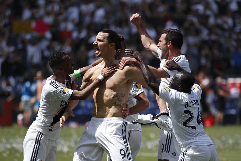 Los Angeles Galaxy's Zlatan Ibrahimovic, center, of Sweden, and teammates celebrate a goal by Ibrahimovic during the second half of an MLS soccer match against the Los Angeles FC Saturday, March 31, 2018, in Carson, Calif. The Galaxy won 4-3. (AP Photo/Jae C. Hong)