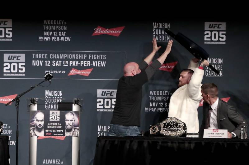 Fighter Conor McGregor, second from right, holds up a chair as UFC president Dana White, center, tries to stop him while Eddie Alvarez, left, looks on during a news conference ahead of the UFC 205 mixed martial arts fights, Thursday, Nov. 10, 2016, at Madison Square Garden in New York. McGregor and Alvarez will fight each other on Saturday. Also seen is fighter Stephen Thompson, far right. (AP Photo/Julio Cortez)