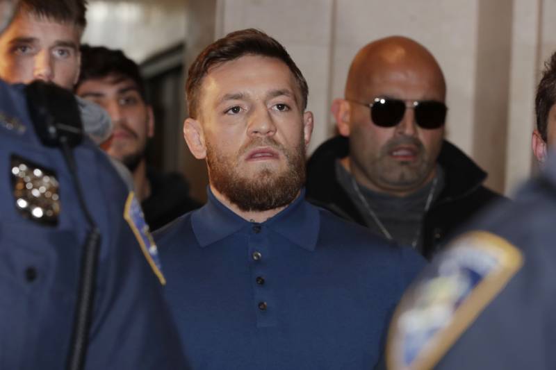 Ultimate fighting star Conor McGregor, center, is escorted by New York Court Police officers after a hearing at the Brooklyn Criminal Court, Friday, April 6, 2018 in New York. McGregor is facing criminal charges in the wake of a backstage melee he allegedly instigated that has forced the removal of three fights from UFC's biggest card of the year. Video footage appears to show the promotion's most bankable star throwing a hand truck at a bus full of fighters after a Thursday news conference for UFC 223 at Brooklyn's Barclays Center. (AP Photo/Julio Cortez)