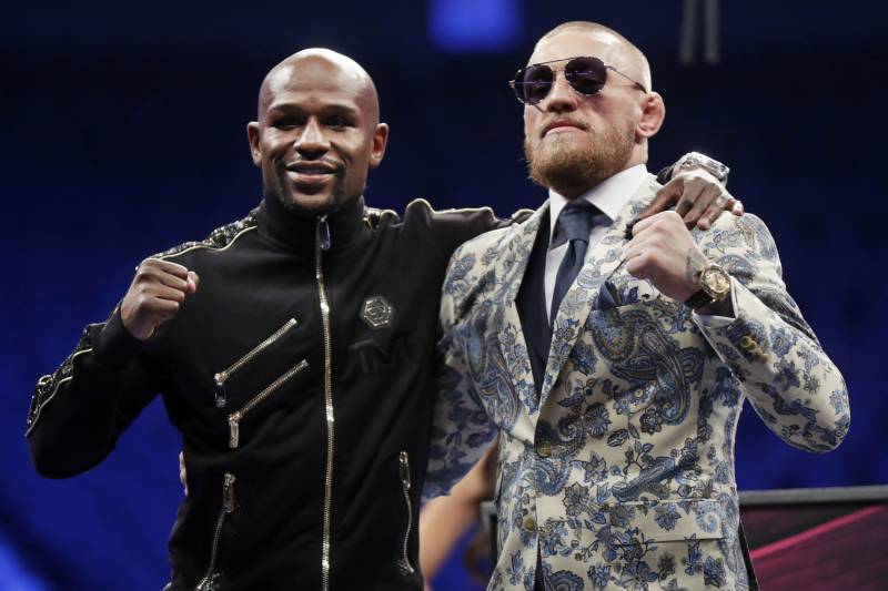 Floyd Mayweather Jr., left, and Conor McGregor pose during a news conference after a super welterweight boxing match Sunday, Aug. 27, 2017, in Las Vegas. (AP Photo/Isaac Brekken)