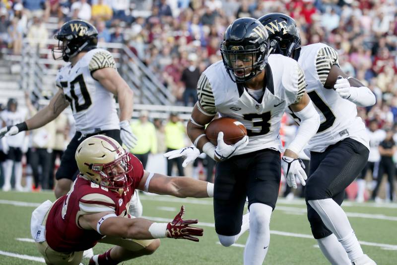 Wake Forest defensive back Jessie Bates III (3) rushes with the ball ahead of Boston College tight end Korab Idrizi, left, after intercepting a pass during the second half of an NCAA college football game, Saturday, Sept. 9, 2017, in Boston. (AP Photo/Mary Schwalm)