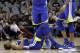 Golden State Warriors' Kevin Durant (35) lies on the court as teammates wait to help him up late in the second half of Game 3 of a first-round NBA basketball playoff series against the San Antonio Spurs in San Antonio, Thursday, April 19, 2018. Golden State won 110-97. (AP Photo/Eric Gay)