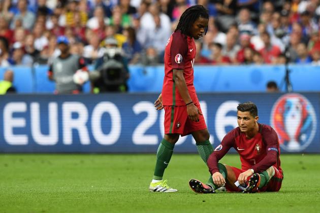 Portugal's midfielder Renato Sanches walks towards Portugal's forward Cristiano Ronaldo as he sits on the pitch during the Euro 2016 final football match between France and Portugal at the Stade de France in Saint-Denis, north of Paris, on July 10, 2016. / AFP / FRANCK FIFE        (Photo credit should read FRANCK FIFE/AFP/Getty Images)