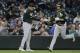 Oakland Athletics' Stephen Piscotty, right, greets third base coach Matt Williams after Piscotty hit a solo home run during the fifth inning of a baseball game against the Seattle Mariners, Thursday, May 3, 2018, in Seattle. (AP Photo/Ted S. Warren)