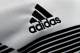 The logo of German sports equipment company adidas AG is printed on a shirt during the annual balance news conference in Herzogenaurach, Germany, Wednesday, March 14, 2018. (AP Photo/Matthias Schrader)