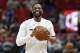 Miami Heat guard Dwyane Wade smiles as he warms up before the start of an NBA basketball game against the Milwaukee Bucks, Friday, Feb. 9, 2018, in Miami. Wade was traded back to the Heat from the Cleveland Cavaliers on Thursday. (AP Photo/Wilfredo Lee)
