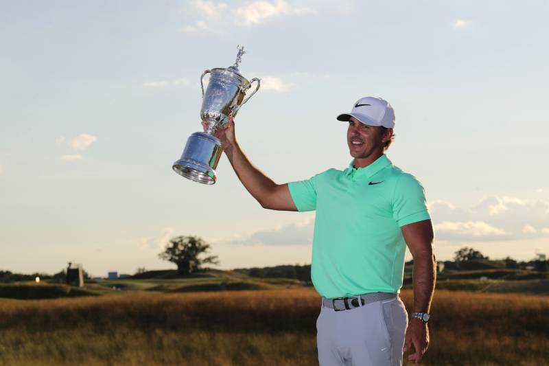 HARTFORD, WI - JUNE 18: Brooks Koepka of the United States poses with the winner's trophy after his victory at the 2017 U.S. Open at Erin Hills on June 18, 2017 in Hartford, Wisconsin. (Photo by Streeter Lecka/Getty Images)