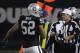 Referee Gene Steratore (114) carries a folded piece of paper used to determine a measurement next to Oakland Raiders defensive end Khalil Mack (52) during the second half of an NFL football game between the Raiders and the Dallas Cowboys in Oakland, Calif., Sunday, Dec. 17, 2017. The Cowboys won 20-17. (AP Photo/Eric Risberg)