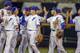 Florida players including Jonathan India, second right, exchange high-fives following an NCAA College World Series baseball elimination game against Texas Tech in Omaha, Neb., Thursday, June 21, 2018. Florida won 9-6. (AP Photo/Nati Harnik)