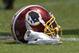 A Washington Redskins football helmet lies on the field during an NFL football team practice, Wednesday, June 6, 2018, in Ashburn, Va. (AP Photo/Nick Wass)