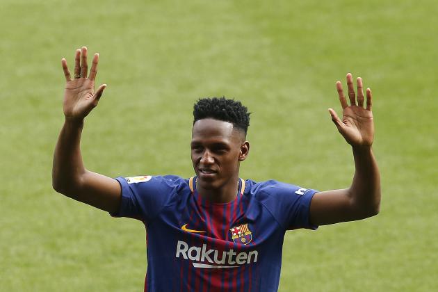 Barcelona's new signing Colombia's Yerry Mina gestures during his official presentation at the Camp Nou stadium in Barcelona, Spain, Saturday, Jan. 13, 2018. Mina took off his shoes and socks before stepping onto the field at Camp Nou Stadium during his official introduction to fans on Saturday. The gesture was an important first step for the defender arriving from Brazilian club Palmeiras. (AP Photo/Manu Fernandez)