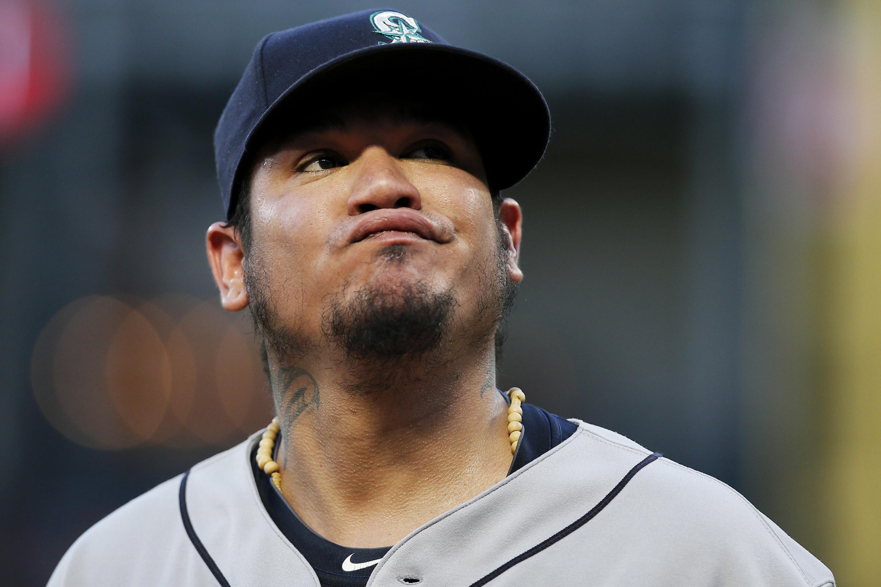 Former Seattle Mariners pitcher Felix Hernandez, front right, talks with  manager Scott Servais, left, after being inducted into the Mariners Hall of  Fame before a baseball game between the Mariners and the